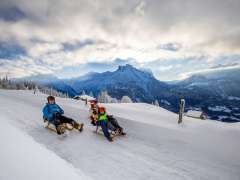 Winter in the Haslital Valley: A young family sledding on the Hasliberg.