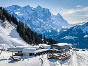 Die Station Mägisalp liegt eingebettet in der winterlichen Berglandschaft auf dem Hasliberg. Rund um die Gebäude verlaufen präparierte Wege und Pisten. Im Hintergrund ragen markante Berggipfel der umliegenden Alpen in den Himmel.