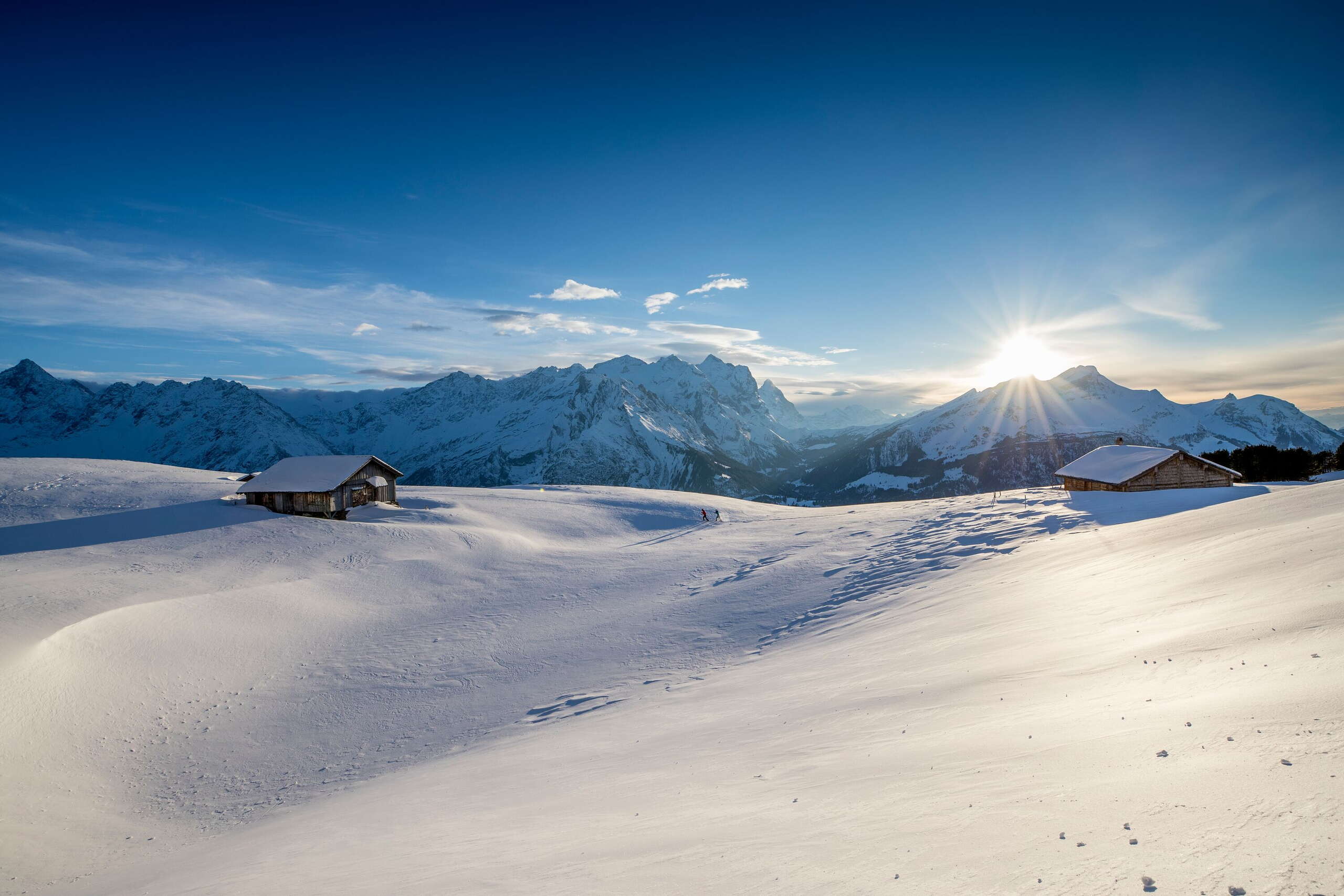 Two hikers in the middle of the snowy winter landscape on the Hasliberg