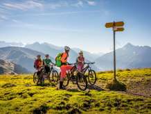 Les cyclistes regardent le panneau indicateur et profitent de la vue depuis le Hasliberg. Le panorama offre une vue estivale sur le paysage montagneux.