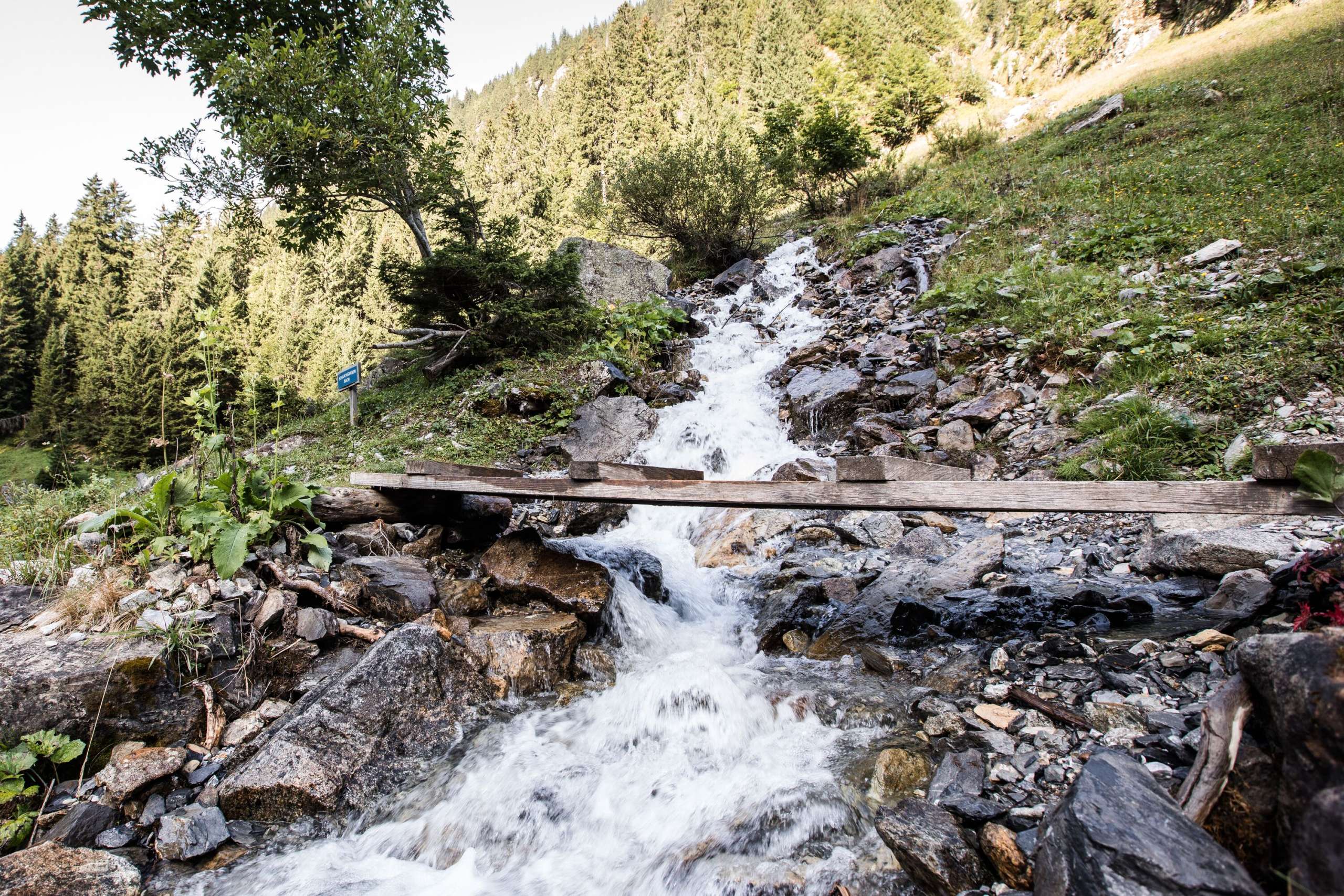 Bergbach mit Brücke Der Bergbach fliesst unaufhaltsam. Eine kleine Brücke führt über den Bach ins hintere Lauterbrunnental.
