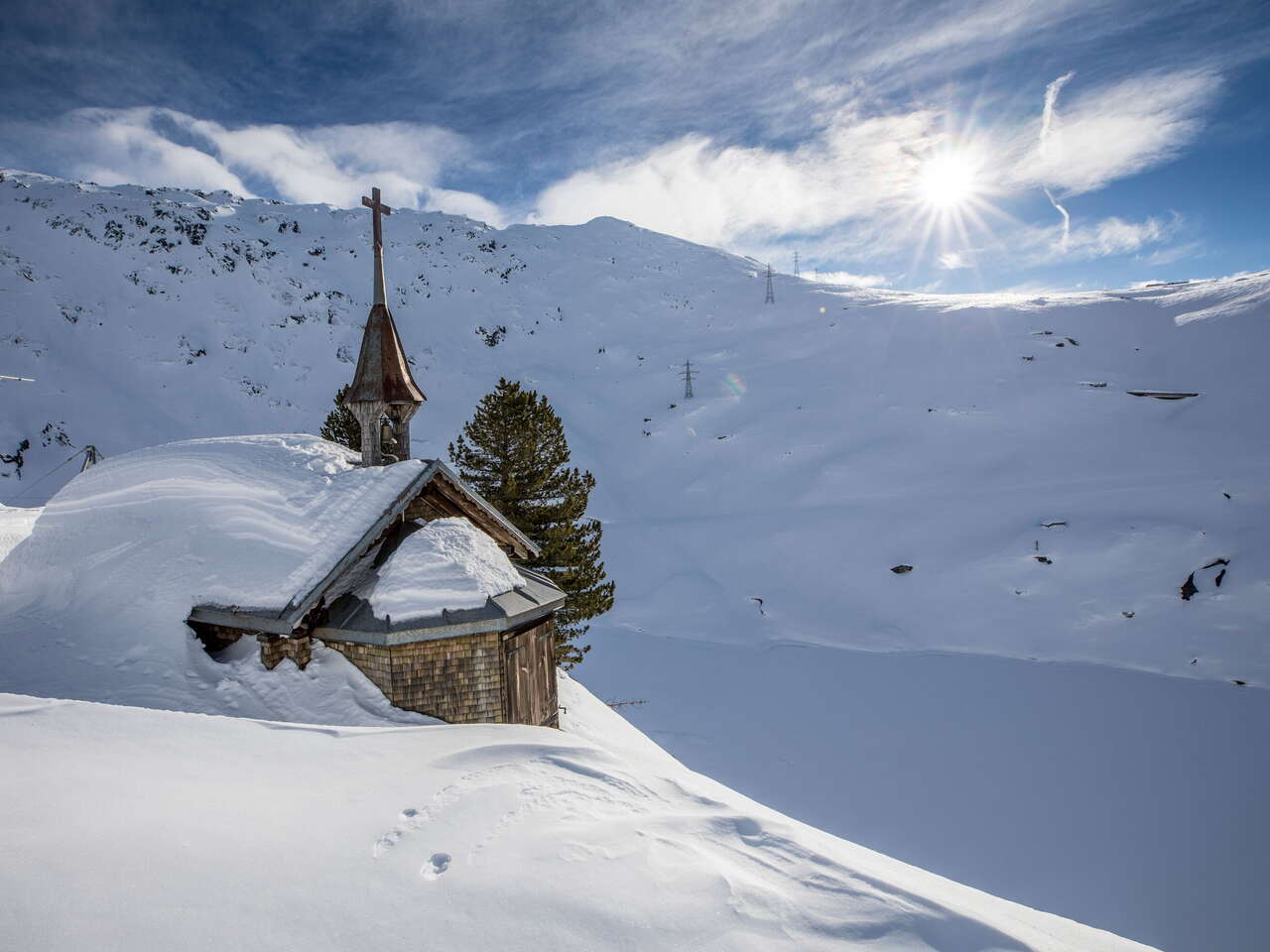 The snow-covered chapel next to the Hotel Grimsel Hospiz in the Grimselwelt in the Haslital.