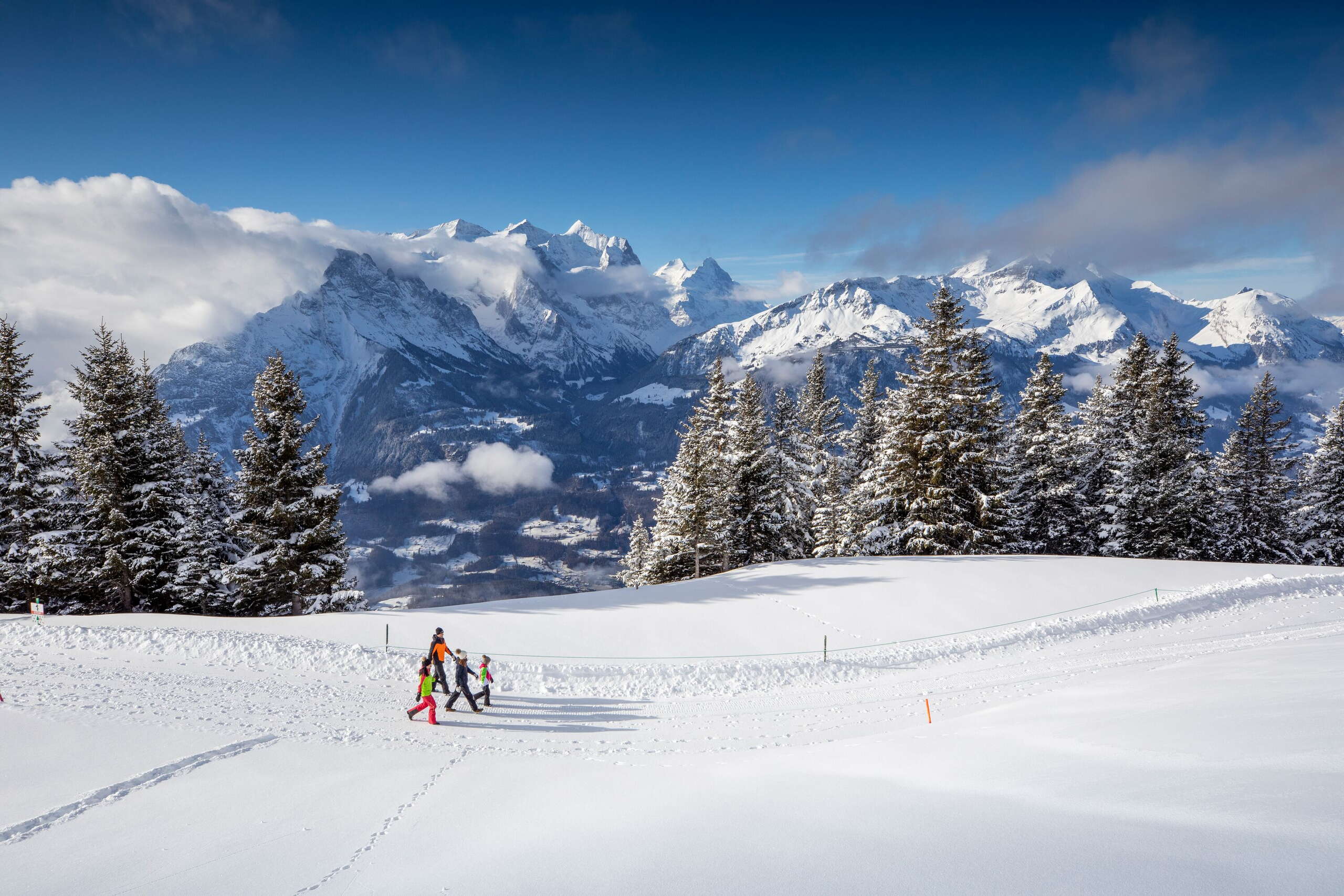 Winter hiking on the Hasliberg: a family out and about against the impressive mountain backdrop.