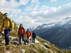 Randonneur au premier plan avec un panorama en arrière-plan, à hauteur de la station amont du Sidelhorn