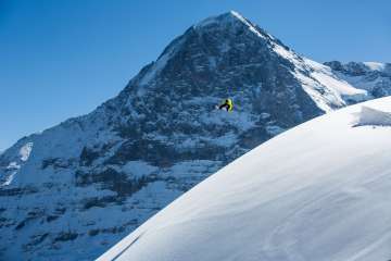 Snowboarding at the Grindelwald-First ski resort. Jumping in fresh powder snow with the Eiger in the background.