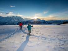At sunset—and against a stunning mountain backdrop: Two snowshoers out and about on the Hasliberg