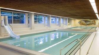 Zwei Schwimmbecken, eines mit Rutschbahn