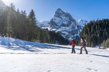 Hiking along the Gschwandtenmad loop trail in the Haslital, surrounded by a stunning mountain backdrop.