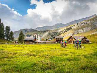 Bikers out for a ride on Hasliberg. In the background, you can see a few houses and rock faces.