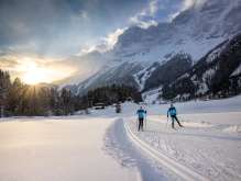 At sunset: Two cross-country skiers on the trail in Guttannen.