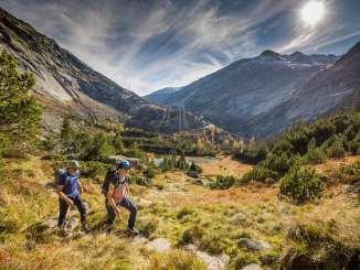 Deux randonneurs en route dans le massif du Grimsel. Ils marchent devant un panorama unique sur le massif du Grimsel.