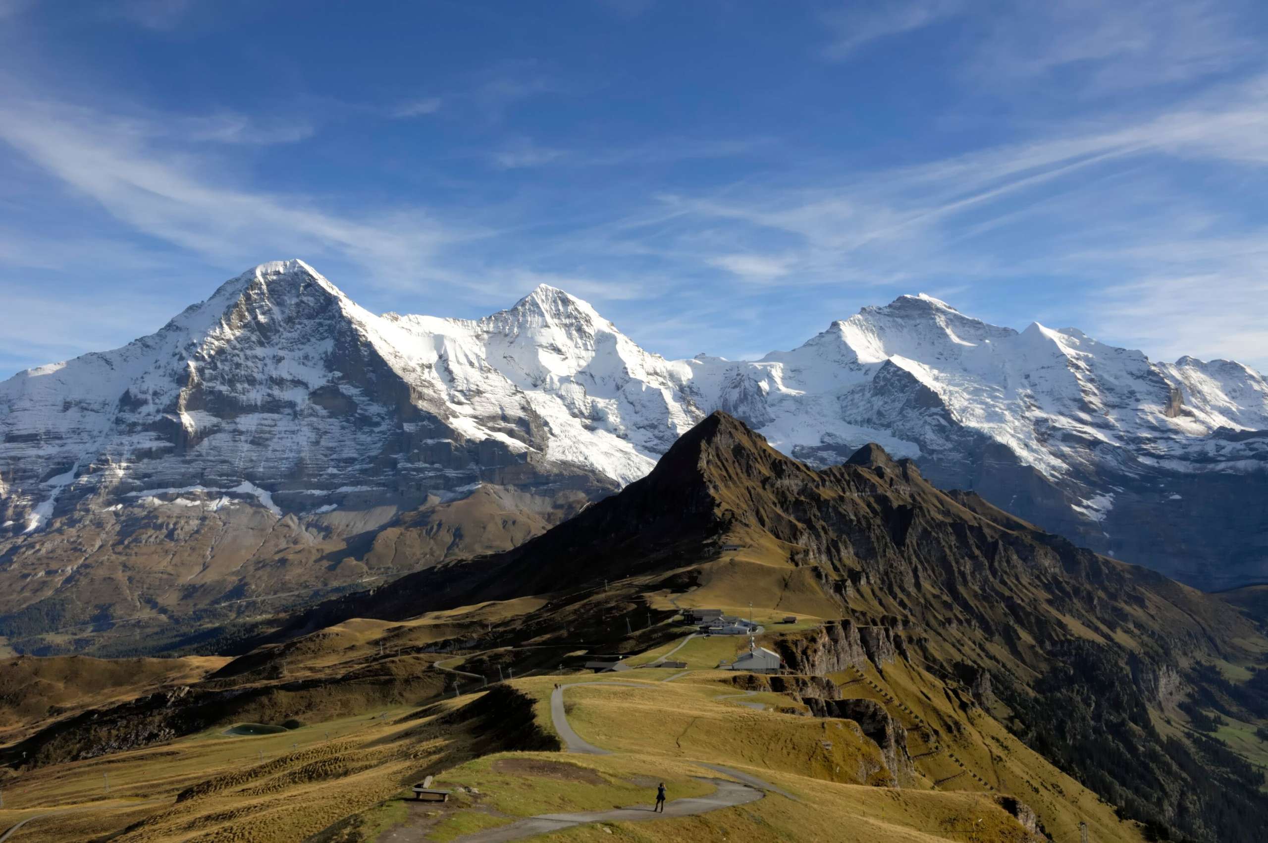 Aussicht Männlichen Aussicht auf den sommerlichen Männlichen mit dem verschneiten Dreigestirn Eiger, Mönch und Jungfrau im Hintergrund.