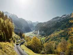 The Wengernalpbahn on its way from Lauterbrunnen to Wengen. In the background, the Lauterbrunnen Valley, bathed in fall colors, with the Staubbach Falls.