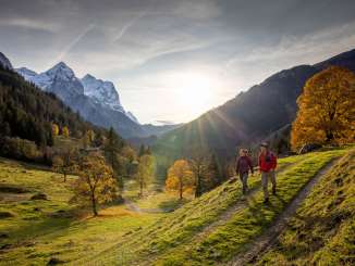 Deux randonneurs parcourent les paysages de la vallée du Rosenlaui. L'ambiance est automnale et le ciel est voilé de légers nuages de brume. Le panorama montagneux est recouvert d'un manteau de neige.