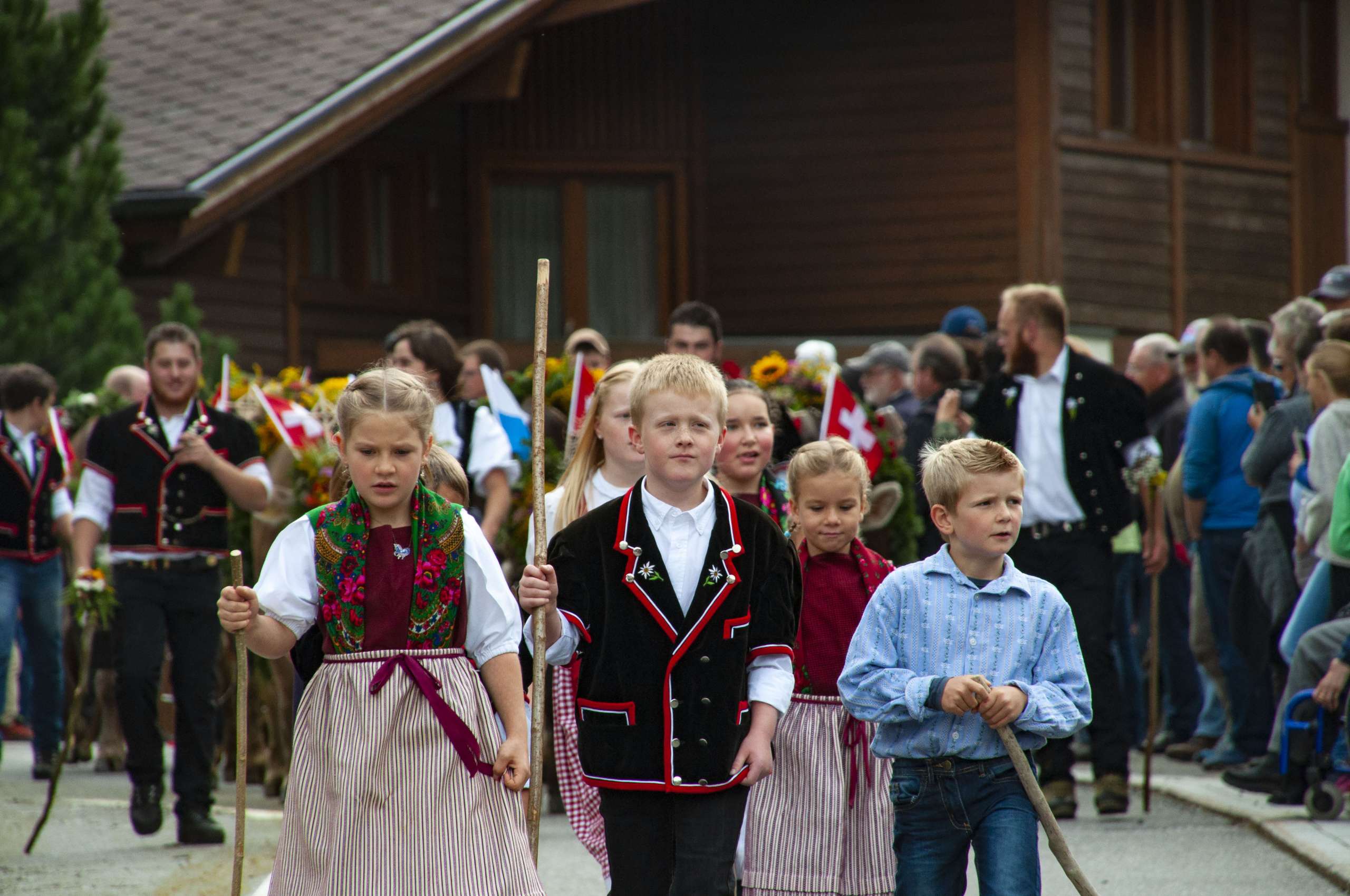 Die Kinder laufen beim Alpabzug Gental in traditionellen Kleidern dem Umzug vorab.
